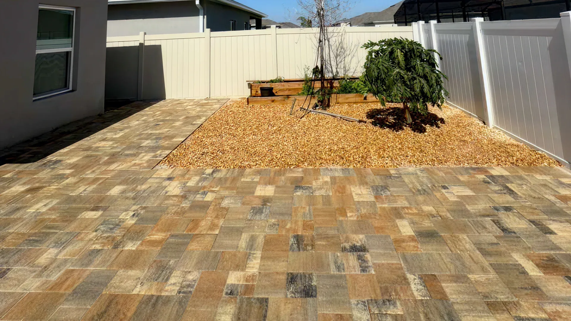 Landscaped paver driveway with outdoor lighting creating a welcoming entrance in Davenport, FL Landscaped paver driveway with outdoor lighting creating a welcoming entrance in Davenport, FL