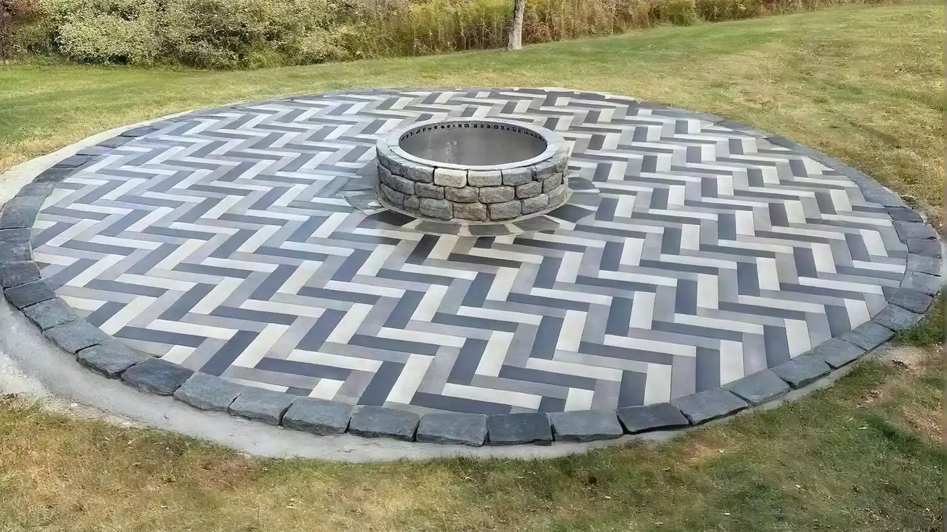 Herringbone paver patio with circular fire pit and soldier course border Herringbone paver patio with circular fire pit and soldier course border