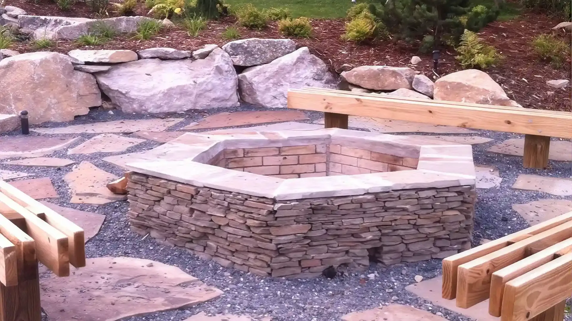 Hexagonal paver fire pit with natural stone seating area Hexagonal paver fire pit with natural stone seating area