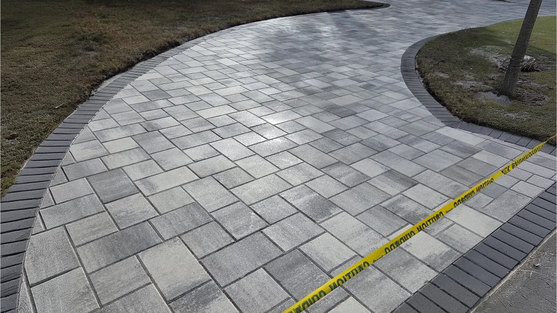 Curved paver walkway with decorative border leading to a Florida home's entrance Curved paver walkway with decorative border leading to a Florida home's entrance