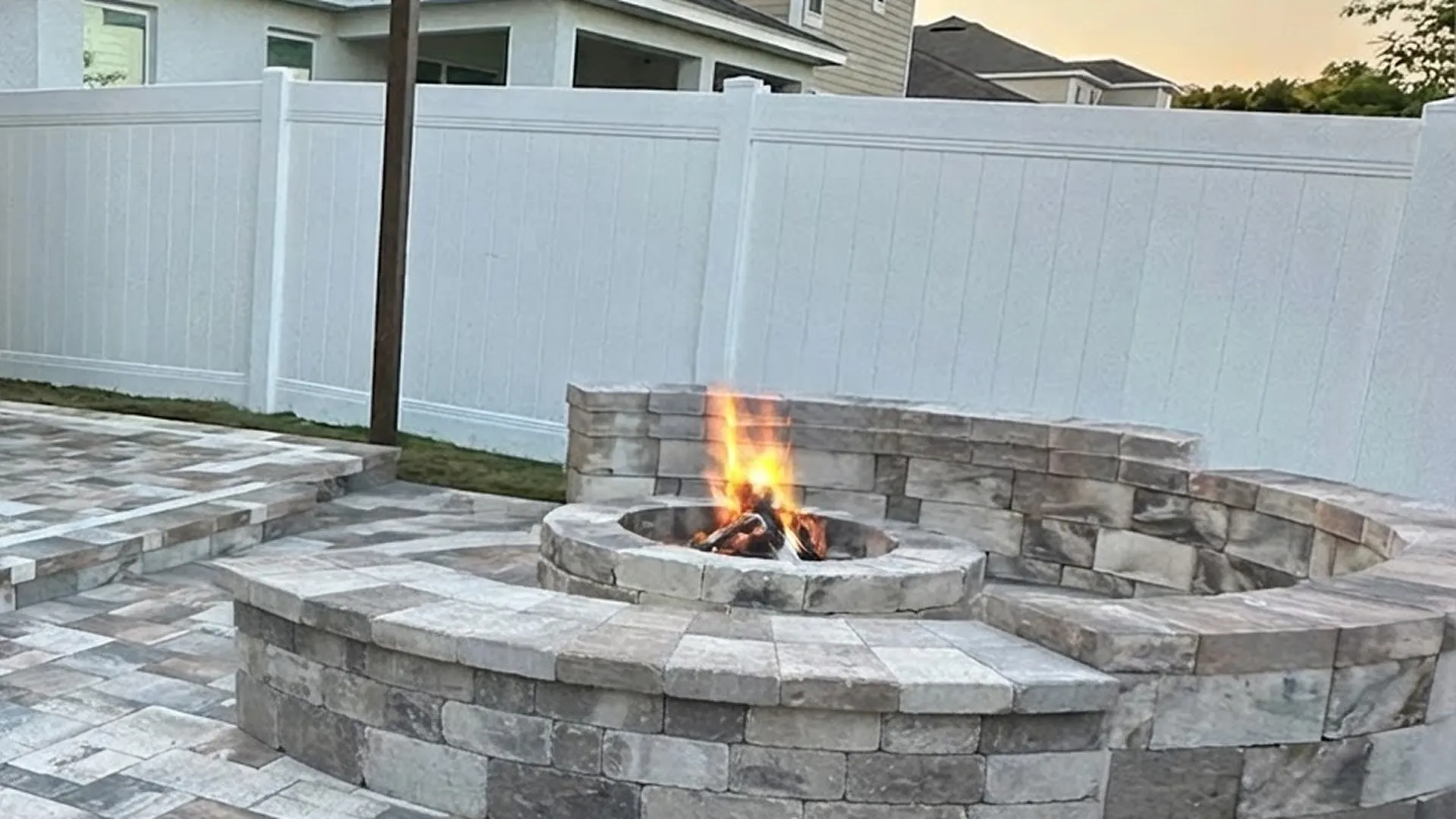 Firepit pavers patio with a built-in seating wall and charcoal paver border in Haines City, FL