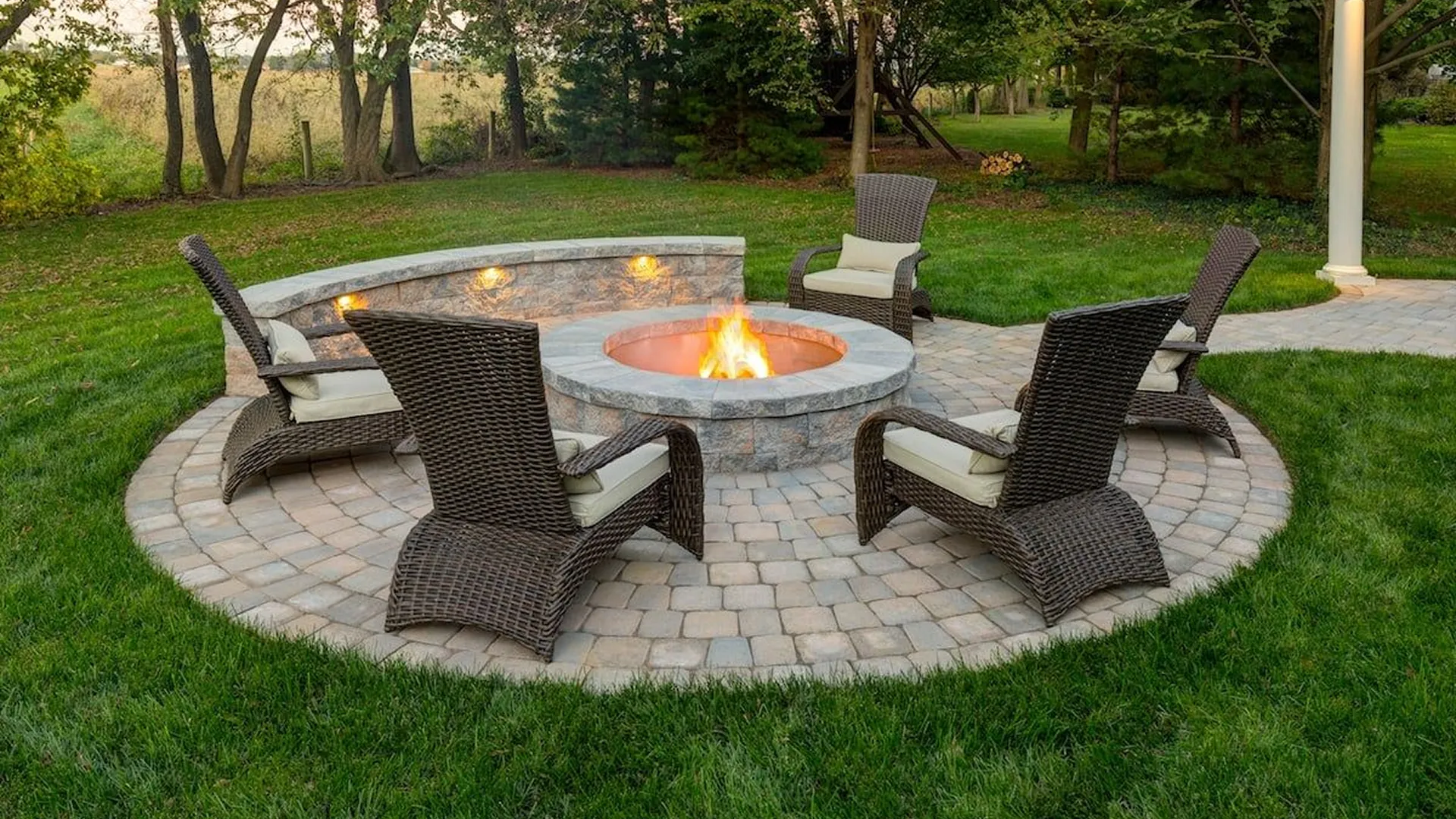 Family gathered around a firepit on a paver patio at night in Haines City, FL