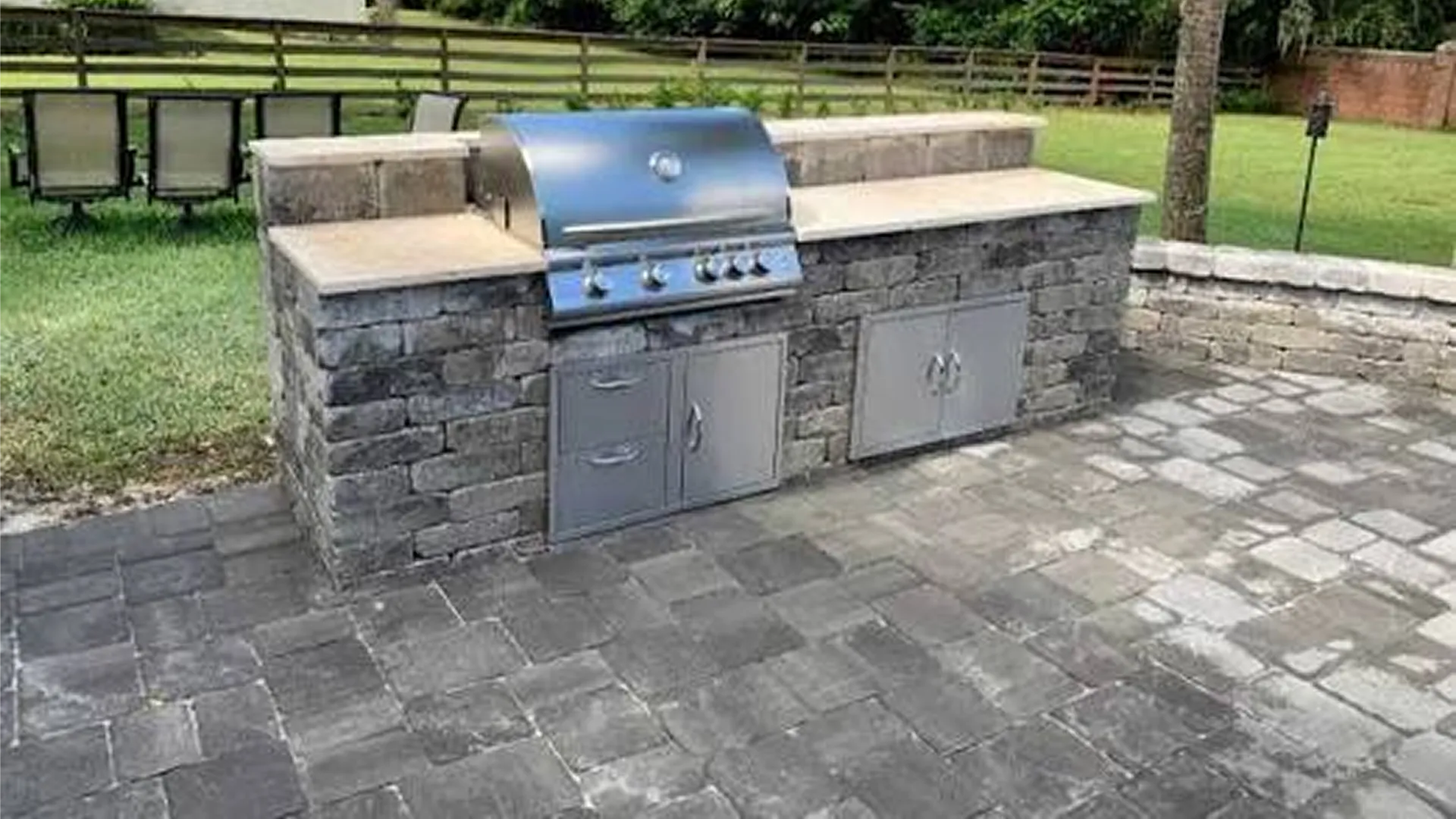 Finished outdoor kitchen pavers patio set up for entertaining guests