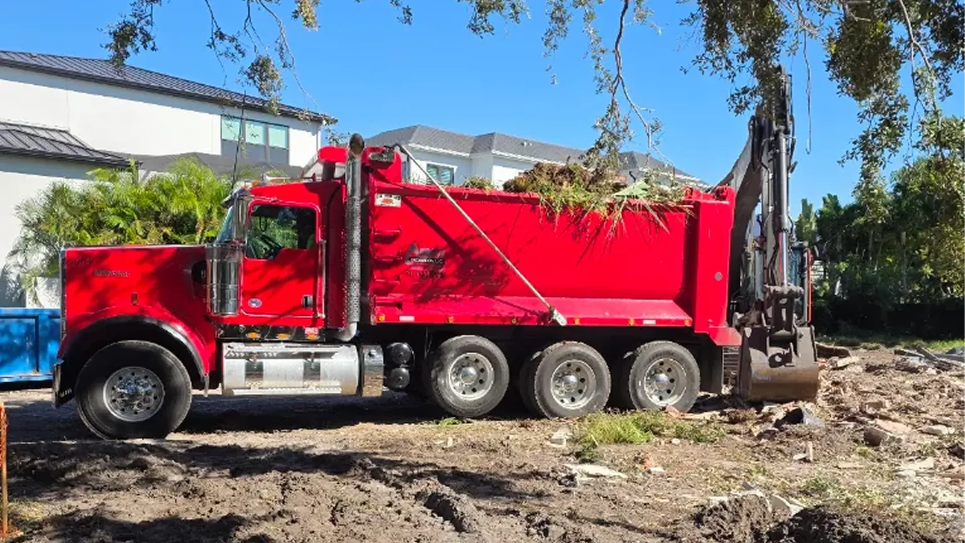 Roll-off dumpster being picked up at a construction site near Zephyrhills, FL
