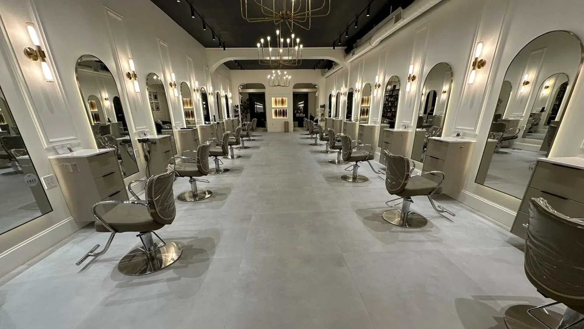 Polished commercial interior with gray tile floor, arched mirrors and styling stations kept clean by a commercial cleaning crew