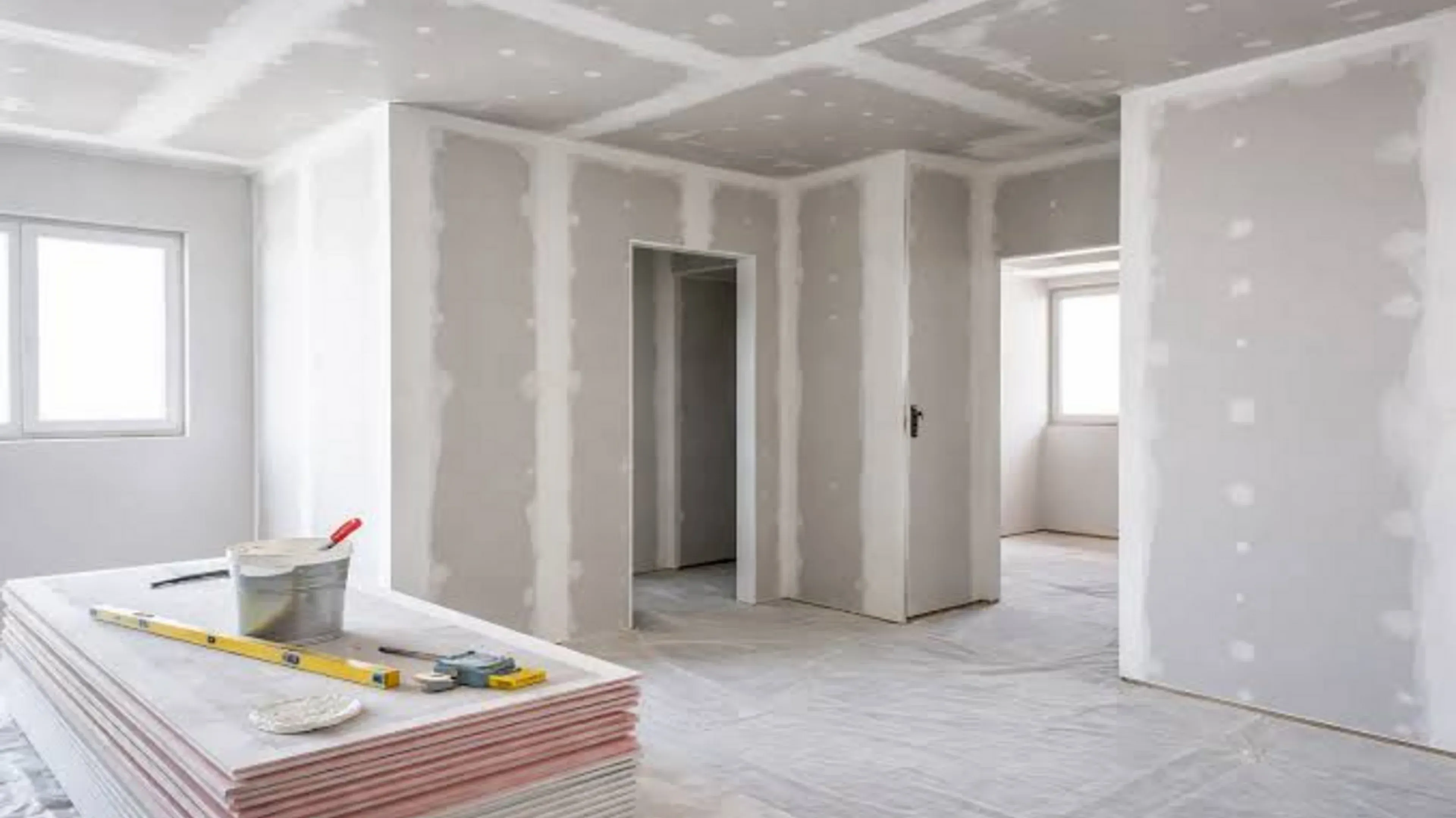 Unfinished residential interior with newly installed drywall by drywall companies near me. Unfinished residential interior with newly installed drywall by drywall companies near me.