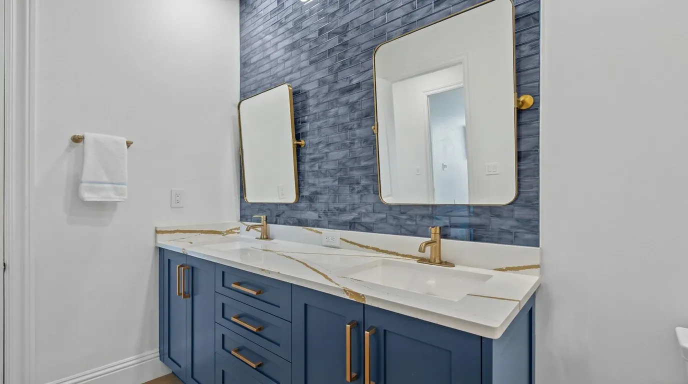 Modern double sink bathroom vanity with engineered quartz countertop and brushed brass plumbing fixtures